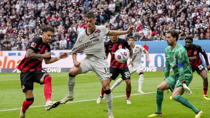Frankfurts Robin Koch, Leverkusens Patrik Schick and Frankfurts goalkeeper Kevin Trapp, from left, challenge for the ball during the German Bundesliga Soccer match between Eintracht Frankfurt and Bayer Leverkusen in Frankfurt, Germany, Sunday, May 5, 2024. (AP Photo/Michael Probst)