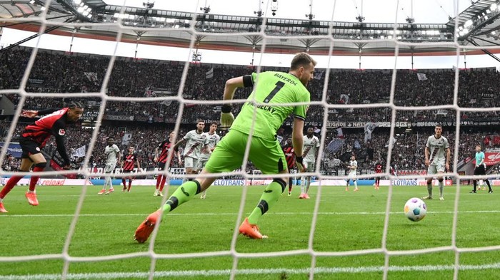05 May 2024, Hesse, Frankfurt/Main: Soccer: Bundesliga, Eintracht Frankfurt - Bayer 04 Leverkusen, Matchday 32, Deutsche Bank Park. Frankfurts Hugo Ekitiké (l) scores the goal to make it 1:1 against Leverkusen goalkeeper Lukas Hradecky. Photo: Arne Dedert/dpa - IMPORTANT NOTE: In accordance with the regulations of the DFL German Football League and the DFB German Football Association, it is prohibited to utilize or have utilized photographs taken in the stadium and/or of the match in the form of sequential images and/or video-like photo series. (Photo by Arne Dedert/picture alliance via Getty Images)