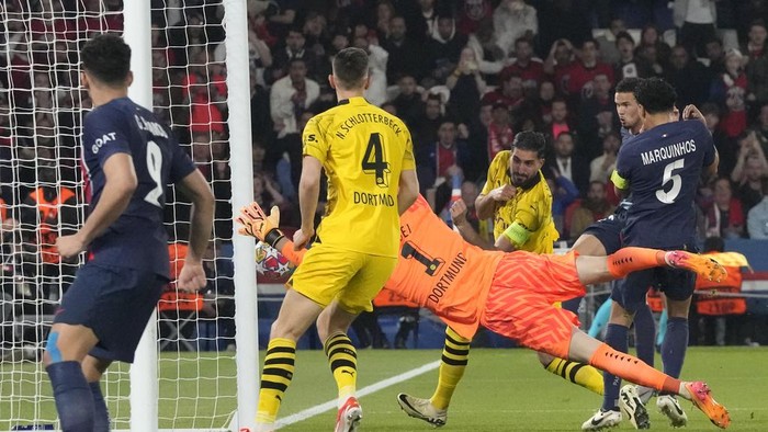 PSG's Warren Zaire-Emery, right background, attempts a shot at goal in front of Dortmund's goalkeeper Gregor Kobel and misses during the Champions League semifinal second leg soccer match between Paris Saint-Germain and Borussia Dortmund at the Parc des Princes stadium in Paris, France, Tuesday, May 7, 2024. (AP Photo/Frank Augstein)