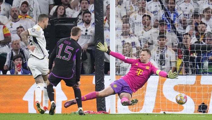 Real Madrids Joselu, left, scores his sides opening goal in front of Bayerns goalkeeper Manuel Neuer, right, during the Champions League semifinal second leg soccer match between Real Madrid and Bayern Munich at the Santiago Bernabeu stadium in Madrid, Spain, Wednesday, May 8, 2024. (AP Photo/Manu Fernandez)