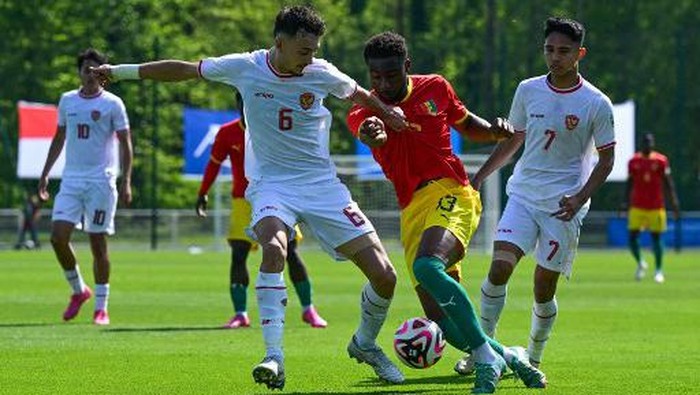 Indonesias midfielder#06 Ivar Jenner (L) fights for the ball with Guineas defender #13 Madiou Keita (C) during the pre-Olympic play-off match between Indonesia and Guinea, for final spot in the mens Olympic football tournament at Paris 2024, in Clairefontaine-en-Yvelines, south of Paris, on May 9, 2024. (Photo by Miguel MEDINA / AFP)