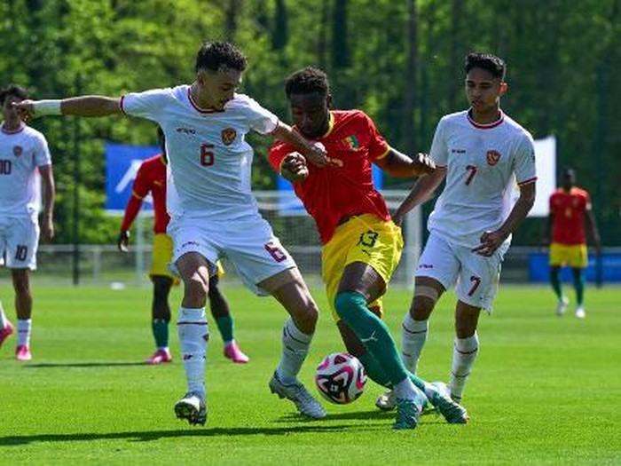 Indonesia's midfielder#06 Ivar Jenner (L) fights for the ball with Guinea's defender #13 Madiou Keita (C) during the pre-Olympic play-off match between Indonesia and Guinea, for final spot in the mens Olympic football tournament at Paris 2024, in Clairefontaine-en-Yvelines, south of Paris, on May 9, 2024. (Photo by Miguel MEDINA / AFP)