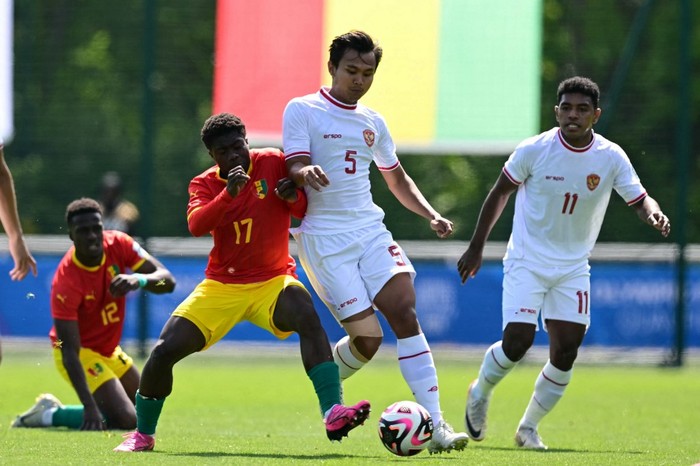 Indonesias  defender#05 Komang Teguh (C) fights for the ball with Guineas  midfielder #17 Issiaga Camara during the pre-Olympic play-off match between Indonesia and Guinea, for final spot in the mens Olympic football tournament at Paris 2024, in Clairefontaine-en-Yvelines, south of Paris, on May 9, 2024. (Photo by MIGUEL MEDINA / AFP)