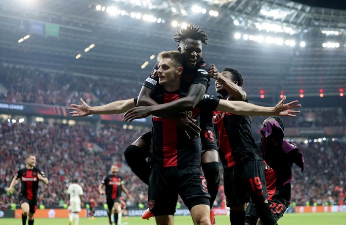 LEVERKUSEN, GERMANY - MAY 09: Josip Stanisic of Bayer Leverkusen celebrates with teammate Arthur after scoring his teams second goal during the UEFA Europa League 2023/24 Semi-Final second leg match between Bayer 04 Leverkusen and AS Roma at BayArena on May 09, 2024 in Leverkusen, Germany. (Photo by Boris Streubel - UEFA/UEFA via Getty Images)