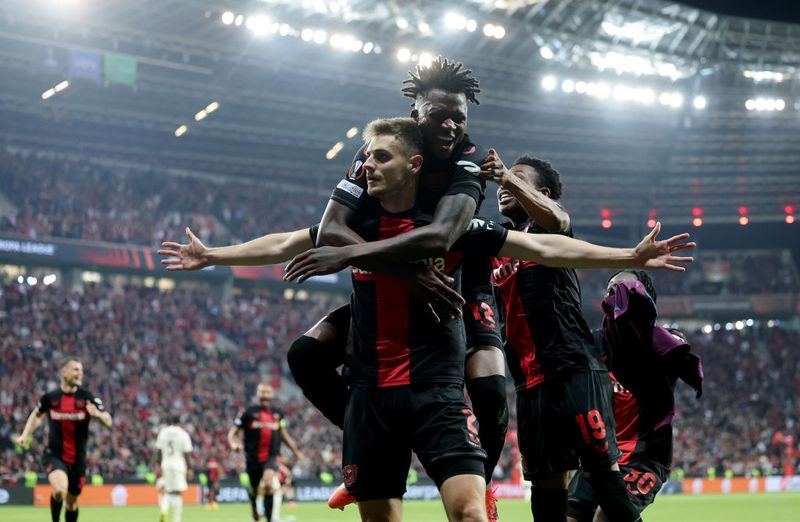 LEVERKUSEN, GERMANY - MAY 09: Josip Stanisic of Bayer Leverkusen celebrates with teammate Arthur after scoring his team's second goal during the UEFA Europa League 2023/24 Semi-Final second leg match between Bayer 04 Leverkusen and AS Roma at BayArena on May 09, 2024 in Leverkusen, Germany. (Photo by Boris Streubel - UEFA/UEFA via Getty Images)