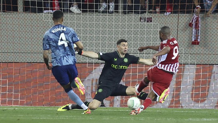 Olympiacos Ayoub El Kaabi, right, kicks the ball to score a goal past Aston Villas goalkeeper Emiliano Martinez during the Europa Conference League semifinal, second leg, soccer match between Olympiacos and Aston Villa at the Georgios Karaiskakis stadium at Athens port of Piraeus, Greece, Thursday, May 9, 2024. (AP Photo/Yorgos Karahalis)