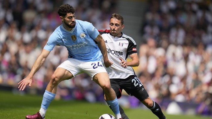 Manchester Citys Josko Gvardiol, left, challenges for the ball with Fulhams Timothy Castagne during the English Premier League soccer match between Fulham and Manchester City at the Craven Cottage Stadium in London, Saturday, May 11, 2024. (AP Photo/Kirsty Wigglesworth)