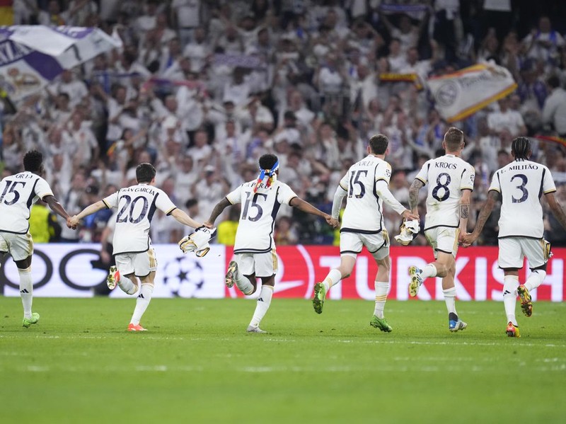 Real Madrid players celebrate at the end of the Champions League semifinal second leg soccer match between Real Madrid and Bayern Munich at the Santiago Bernabeu stadium in Madrid, Spain, Wednesday, May 8, 2024. (AP Photo/Manu Fernandez)