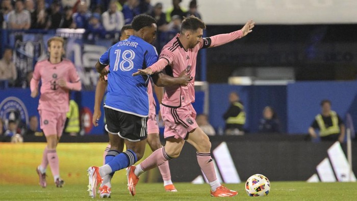 May 11, 2024; Montreal, Quebec, CAN; Inter Miami CF forward Lionel Messi (10) and CF Montreal midfielder Rida Zouhir (18) battle for the ball in the second half at Stade Saputo. Mandatory Credit: Eric Bolte-USA TODAY Sports