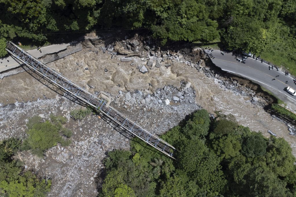 This drone shot shows a road damaged by a flash flood in Tanah Datar, West Sumatra, Indonesia, Sunday, May 12, 2024. Heavy rains and torrents of cold lava and mud flowing down a volcano's slopes on Indonesia's Sumatra island triggered flash floods that killed and injured a number of people, officials said Sunday. (AP Photo/Sutan Malik Kayo)