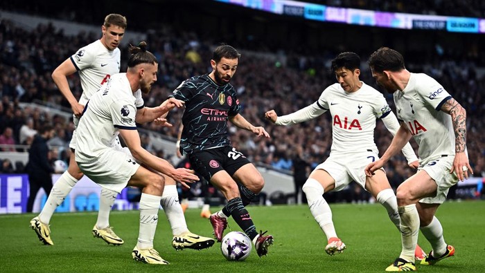 Liga Inggris Soccer Football - Premier League - Tottenham Hotspur v Manchester City - Tottenham Hotspur Stadium, London, Britain - May 14, 2024 Manchester City's Bernardo Silva in action with Tottenham Hotspur's Radu Dragusin, Son Heung-min and Pierre-Emile Hojbjerg REUTERS/Dylan Martinez EDITORIAL USE ONLY. NO USE WITH UNAUTHORIZED AUDIO, VIDEO, DATA, FIXTURE LISTS, CLUB/LEAGUE LOGOS OR 'LIVE' SERVICES. ONLINE IN-MATCH USE LIMITED TO 120 IMAGES, NO VIDEO EMULATION. NO USE IN BETTING, GAMES OR SINGLE CLUB/LEAGUE/PLAYER PUBLICATIONS. PLEASE CONTACT YOUR ACCOUNT REPRESENTATIVE FOR FURTHER DETAILS..