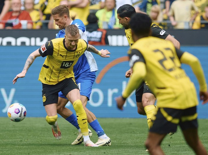 Dortmunds Marco Reus, left, and Darmstadts Tobias Kempe fight for the ball during the Bundesliga soccer match between Borussia Dortmund and SV Darmstadt 98 at the Signal Iduna Park in Dortmund, Germany, Saturday May 18, 2024. (Bernd Thissen/dpa via AP)