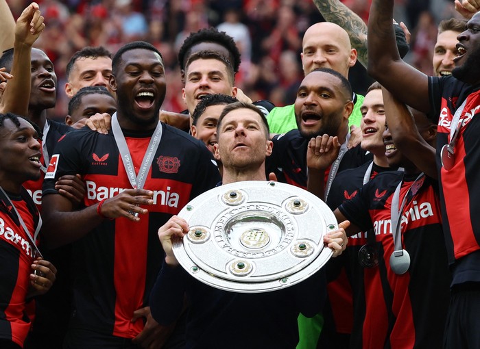 Soccer Football - Bundesliga - Bayer Leverkusen v FC Augsburg - BayArena, Leverkusen, Germany - May 18, 2024 Bayer Leverkusen coach Xabi Alonso celebrates with the trophy after winning the Bundesliga and going unbeaten REUTERS/Wolfgang Rattay DFL REGULATIONS PROHIBIT ANY USE OF PHOTOGRAPHS AS IMAGE SEQUENCES AND/OR QUASI-VIDEO.