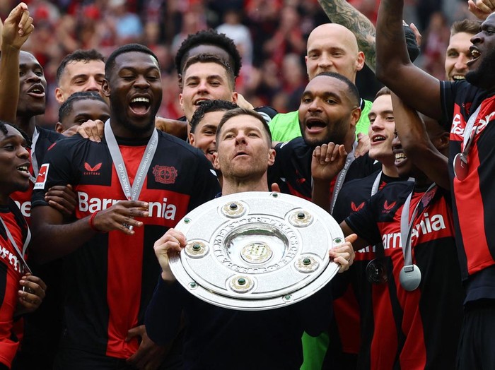 Soccer Football - Bundesliga - Bayer Leverkusen v FC Augsburg - BayArena, Leverkusen, Germany - May 18, 2024 Bayer Leverkusen coach Xabi Alonso celebrates with the trophy after winning the Bundesliga and going unbeaten REUTERS/Wolfgang Rattay DFL REGULATIONS PROHIBIT ANY USE OF PHOTOGRAPHS AS IMAGE SEQUENCES AND/OR QUASI-VIDEO.