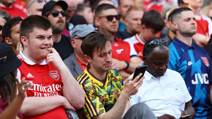 Soccer Football - Premier League - Arsenal v Everton - Emirates Stadium, London, Britain - May 19, 2024  Arsenal fans check their phones after Manchester Citys Phil Foden scores their second goal against West Ham United Action Images via Reuters/Paul Childs EDITORIAL USE ONLY. NO USE WITH UNAUTHORIZED AUDIO, VIDEO, DATA, FIXTURE LISTS, CLUB/LEAGUE LOGOS OR LIVE SERVICES. ONLINE IN-MATCH USE LIMITED TO 120 IMAGES, NO VIDEO EMULATION. NO USE IN BETTING, GAMES OR SINGLE CLUB/LEAGUE/PLAYER PUBLICATIONS. PLEASE CONTACT YOUR ACCOUNT REPRESENTATIVE FOR FURTHER DETAILS..