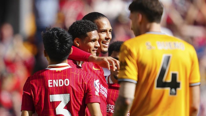 Liverpools Jarell Quansah, second left, celebrates with teammates after scoring his sides second goal during the English Premier League soccer match between Liverpool and Wolverhampton Wanderers at Anfield Stadium in Liverpool, England, Sunday, May 19, 2024. (AP Photo/Jon Super)