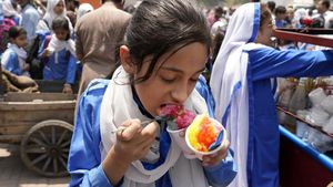 Siswa di Pakistan Ngemil Es Serut Ditengah Panasnya Cuaca