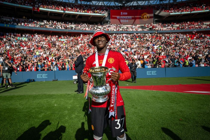 LONDON, ENGLAND - MAY 25: Kobbie Mainoo of Manchester United celebrates with the Emirates FA Cup trophy after winning the Emirates FA Cup Final match between Manchester City and Manchester United at Wembley Stadium on May 25, 2024 in London, England. (Photo by Ash Donelon/Manchester United via Getty Images)