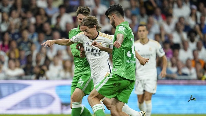 Soccer Football - LaLiga - Real Madrid v Real Betis - Santiago Bernabeu, Madrid, Spain - May 25, 2024 Real Madrids Luka Modric in action with Real Betis Juan Miranda and Ricardo Visus REUTERS/Ana Beltran