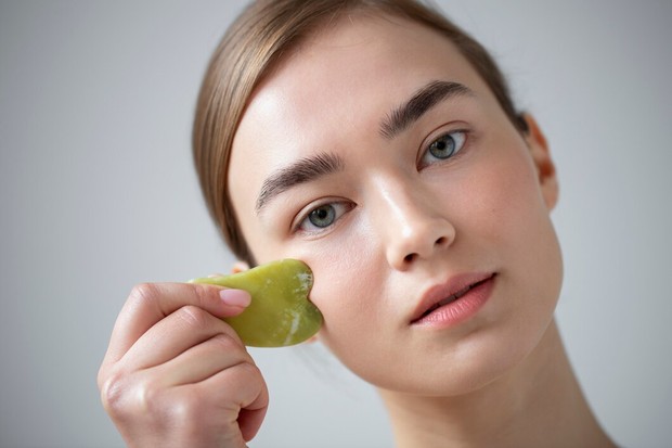 Potret ilustrasi perempuan melakukan facial guasha