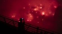 Suporter Olympiakos menyalakan suar berwara merah merayakan gelar juara Conference League. AP/Michael Varaklas  