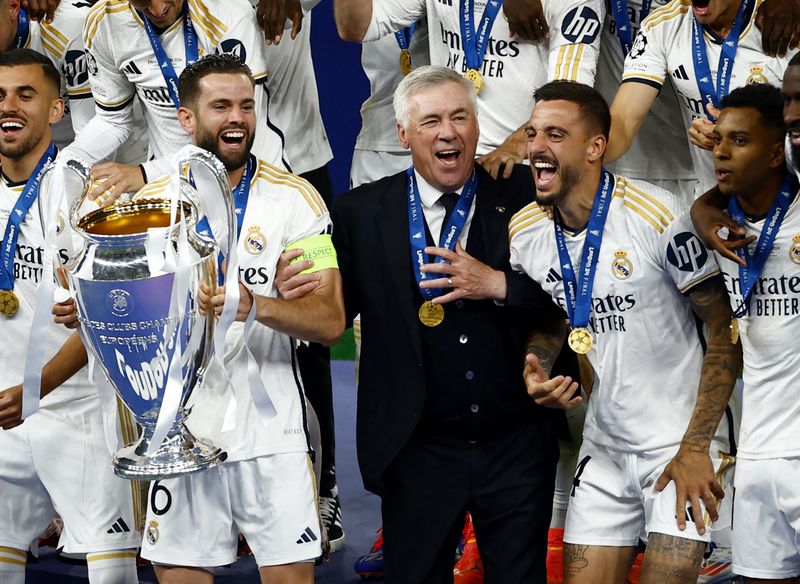 Soccer Football - Champions League - Final - Borussia Dortmund v Real Madrid - Wembley Stadium, London, Britain - June 1, 2024 Real Madrid's Nacho lifts the trophy as he celebrates with Joselu, Rodrygo and coach Carlo Ancelotti after winning the Champions League REUTERS/Sarah Meyssonnier