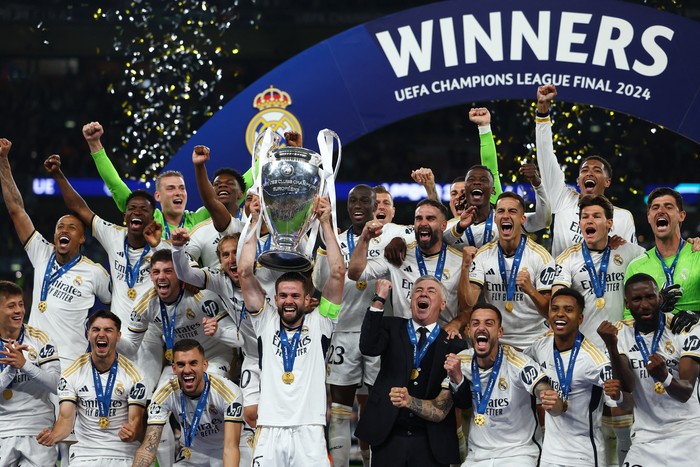Soccer Football - Champions League - Final - Borussia Dortmund v Real Madrid - Wembley Stadium, London, Britain - June 1, 2024 Real Madrid's Dani Carvajal lifts the trophy as he celebrates with teammates and coach Carlo Ancelotti after winning the Champions League REUTERS/Hannah Mckay