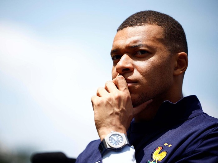 French soccer player Kylian Mbappe listens to French President Emmanuel Macron as he arrives for a lunch at their training camp ahead of the UEFA Euro 2024, in Clairefontaine-en-Yvelines, France, June 3, 2024. REUTERS/Sarah Meyssonnier/Pool