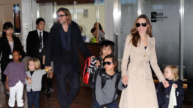 Accompanied by their children, US movie stars Brad Pitt and Angellina Jolie appear before photographers upon their arrival at Haneda Airport in Tokyo on November 8, 2011. Brad Pitt is here for the Japan premiere of his last film 'Moneyball'.   AFP PHOTO/Toru YAMANAKA (Photo by TORU YAMANAKA / AFP)