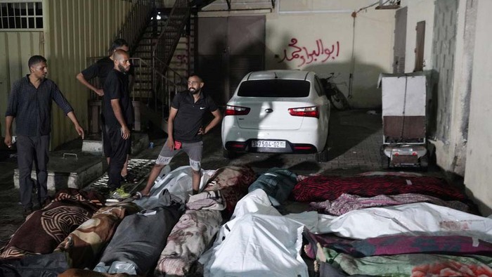 Palestinians mourn their relatives killed in an Israeli bombardment of UNRWA school at Nusseirat refugee camp, in front of the morgue of al-Aqsa Martyrs hospital in Deir al-Balah, central Gaza Strip, early Thursday, June 6, 2024. (AP Photo/Abdel Kareem Hana)