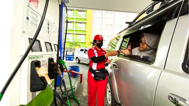 Petugas SPBU sedang meyalani konsumen