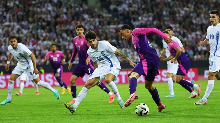 07 June 2024, North Rhine-Westphalia, Mönchengladbach: Soccer: International match, Germany - Greece, stadium in Borussia-Park, Greeces Lazaros Rota (M) and Germanys Jamal Musiala (center r) fight for the ball. Photo: Christian Charisius/dpa (Photo by Christian Charisius/picture alliance via Getty Images)