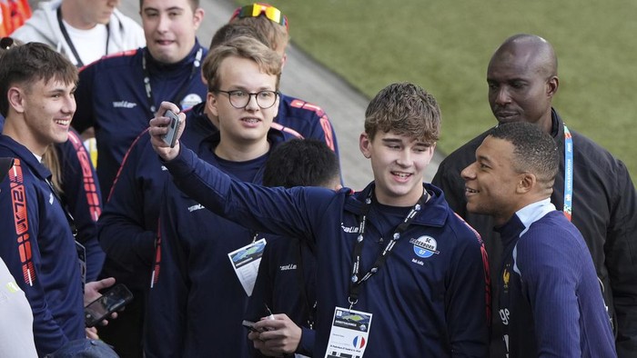 France's Kylian Mbappe poses for a photograph with his fans during a training session in Paderborn, Germany, Thursday, June 13, 2024. France striker Kylian Mbappé was absent when the squad took part in an open practice session at its European Championship base on Thursday. France will play against Austria during their Group D soccer match at the Euro 2024 soccer tournament on June 17. (AP Photo/Hassan Ammar)