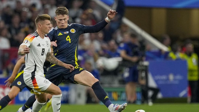 Scotlands Scott McTominay, right, duels for the ball with Germanys Toni Kroos during a Group A match between Germany and Scotland at the Euro 2024 soccer tournament in Munich, Germany, Friday, June 14, 2024. (AP Photo/Antonio Calanni)