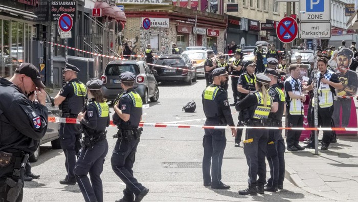 Police cordon off an area near the Reeperbahn in Hamburg, Germany, Sunday, June 16, 2024. German police say officers have shot and wounded a man who was threatening them with an axe and a firebomb in the northern city of Hamburg, hours before the city hosts a match in the Euro 2024 soccer tournament. (Bodo Marks/dpa via AP)