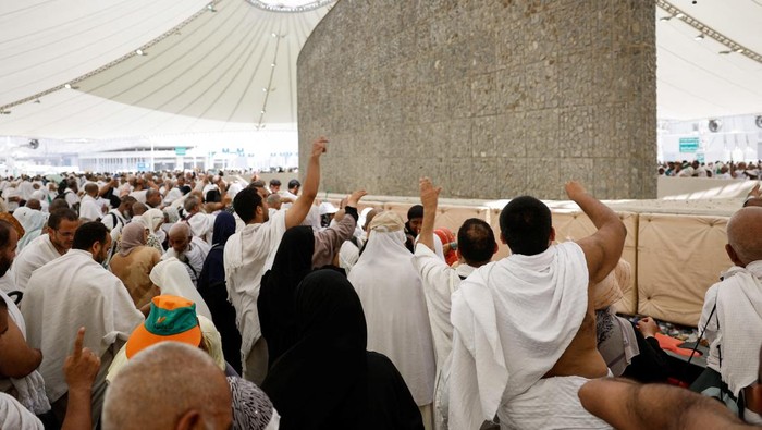 Tangis Haru Jemaah Haji Saat Lempar Jumrah A woman reacts as Muslim pilgrims cast stones at a pillar symbolising Satan, during the annual haj pilgrimage in Mina, Saudi Arabia, June 16, 2024. REUTERS/Saleh Salem lempar jumrah