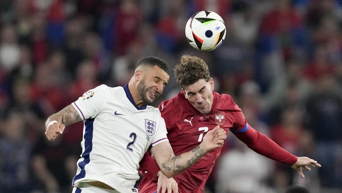 Englands Kyle Walker, left, vies for a header next to Serbias Dusan Vlahovic during the second half in a Group C match between Serbia and England at the Euro 2024 soccer tournament in Gelsenkirchen, Germany, Monday, June 17, 2024. (AP Photo/Thanassis Stavrakis)