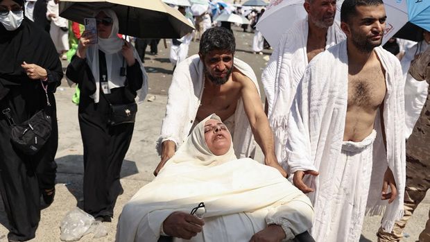 A woman effected by the scorching heat is pushed on a wheelchair as Muslim pilgrims arrive to perform the symbolic 'stoning of the devil' ritual as part of the hajj pilgrimage in Mina, near Saudi Arabia's holy city of Mecca, on June 16, 2024. Pilgrims perform the last major ritual of the hajj, the 