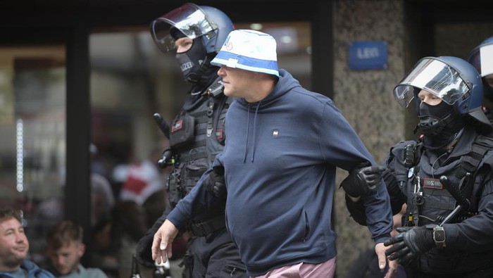 Police detain an England soccer fan ahead the Group C match between Serbia and England at the Euro 2024 soccer tournament in Gelsenkirchen, Germany, Sunday, June 16, 2024. (AP Photo/Markus Schreiber)