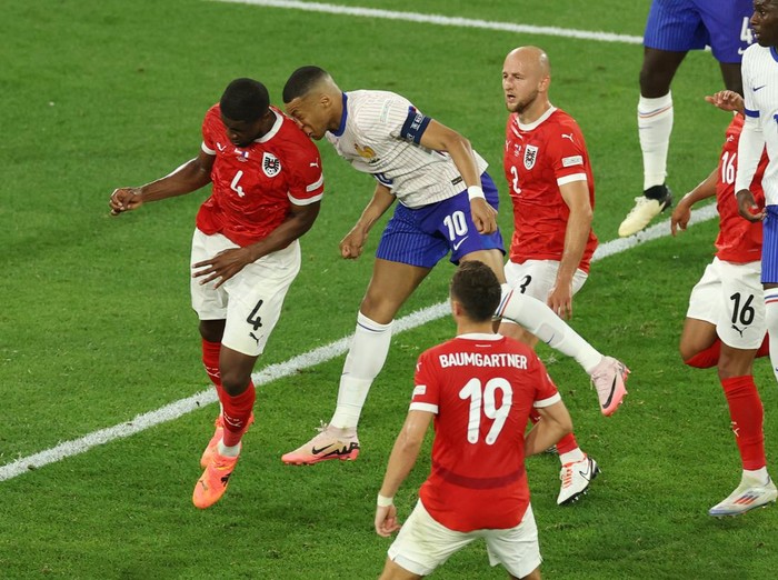 DUSSELDORF, GERMANY - JUNE 17: (EDITORS NOTE: Image contains graphic content.) Kylian Mbappe of France clashes heads with Kevin Danso of Austria during the UEFA EURO 2024 group stage match between Austria and France at Düsseldorf Arena on June 17, 2024 in Dusseldorf, Germany. (Photo by Lars Baron/Getty Images)
