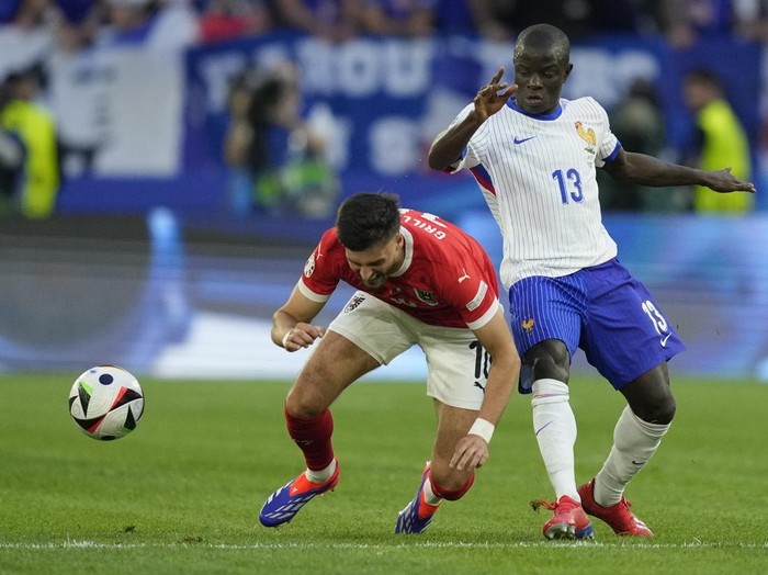 Austria's Florian Grillitsch is challenged by N'Golo Kante of France during a Group D match between Austria and France at the Euro 2024 soccer tournament in Duesseldorf, Germany, Monday, June 17, 2024. (AP Photo/Andreea Alexandru)