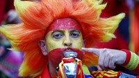 Seorang penggemar Spanyol mengecat wajah dan rambutnya saat mendukung timnas kebanggan berlaga di Euro 2024. REUTERS/Kacper Pempel