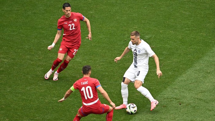 Soccer Football - Euro 2024 - Group C - Slovenia v Serbia - Munich Football Arena, Munich, Germany - June 20, 2024 Slovenias Timi Max Elsnik in action with Serbias Dusan Tadic and Sasa Lukic REUTERS/Angelika Warmuth