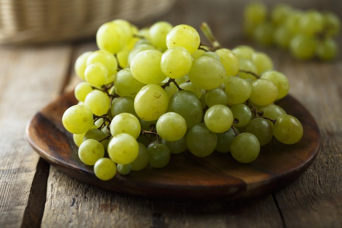 1132942631 Ripe white grape on wooden desk anggur cotton candy
