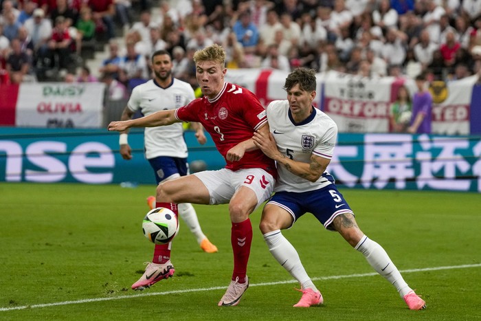 Denmarks Rasmus Hojlund, left, is challenged by Englands John Stones during a Group C match between Denmark and England at the Euro 2024 soccer tournament in Frankfurt, Germany, Thursday, June 20, 2024. (AP Photo/Thanassis Stavrakis)