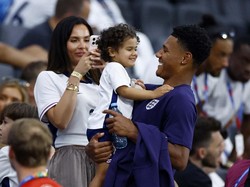 Pemain Inggris Ollie Watkins menggendong putrinya Amara May di tribun penonton setelah pertandingan. REUTERS/John Sibley. 