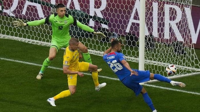 Slovakias Ivan Schranz (26) shoots against Ukraines Oleksandr Zinchenko, center, and goalkeeper Anatoliy Trubin (12) during a Group E match between Slovakia and Ukraine at the Euro 2024 soccer tournament in Duesseldorf, Germany, Friday, June 21, 2024. (AP Photo/Alessandra Tarantino)