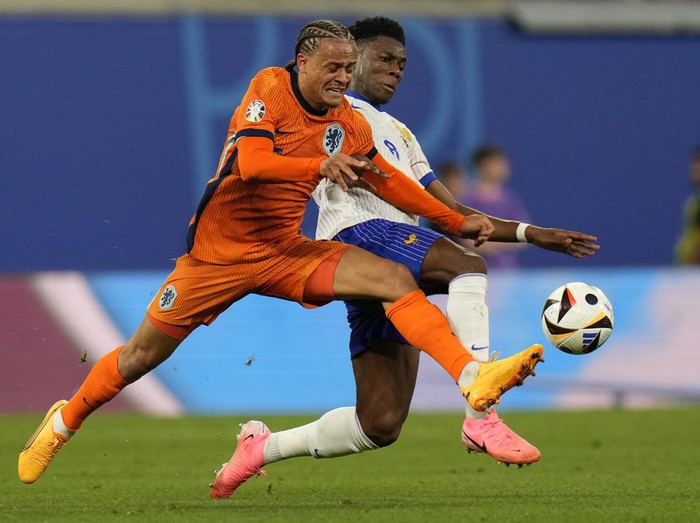 Xavi Simons of the Netherlands, left, is challenged by Aurelien Tchouameni of France during the Group D match between the Netherlands and France at the Euro 2024 soccer tournament in Leipzig, Germany, Friday, June 21, 2024. (AP Photo/Hassan Ammar)