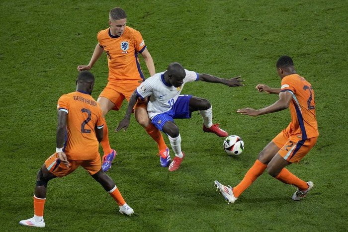 NGolo Kante of France, center, tries to keep the ball as Denzel Dumfries of the Netherlands, right, Joey Veerman, background, and Lutsharel Geertruida defend against him during a Group D match between the Netherlands and France at the Euro 2024 soccer tournament in Leipzig, Germany, Friday, June 21, 2024. (AP Photo/Sergei Grits)