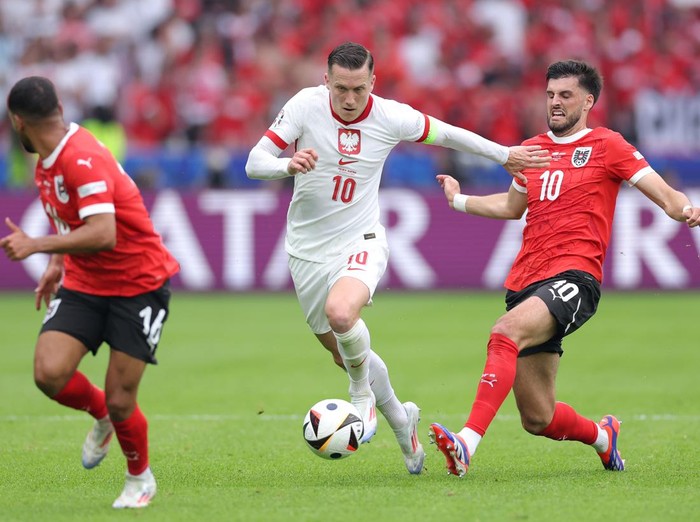 BERLIN, GERMANY - JUNE 21: Piotr Zielinski of Poland is challenged by Florian Grillitsch of Austria during the UEFA EURO 2024 group stage match between Poland and Austria at Olympiastadion on June 21, 2024 in Berlin, Germany. (Photo by Alex Livesey/Getty Images)